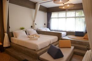 a bedroom with a large bed and a couch at Krung Boutique Hotel in Bangkok