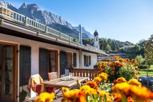 eine Terrasse mit einem Tisch, Blumen und einem Leuchtturm in der Unterkunft Haus Huis'n in Grainau