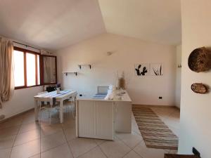 een witte kamer met een tafel en een tafel en een tafel en een raam bij Bilocale n 10 Arbatax vicino al mare in Àrbatax