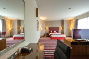 een hotelkamer met 2 bedden en een grote spiegel bij Wonder Palace Hotel Qatar in Doha