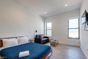 a bedroom with a king sized bed and a chair at River West, Second Floor Chicago by 747 Lofts in Chicago