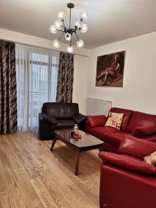 ein Wohnzimmer mit einem roten Sofa und einem Tisch in der Unterkunft Aurora BW in Belgrad