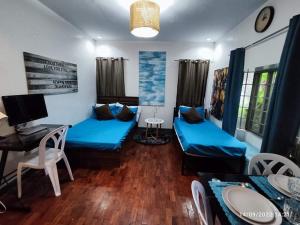 sala de estar con sofás azules y escritorio en JOIZ HOMESTAY en San Pedro