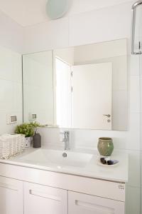 a white bathroom with a sink and a mirror at The Coffee Houses Center in Tel Aviv