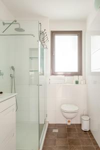 a white bathroom with a toilet and a window at The Coffee Houses Center in Tel Aviv