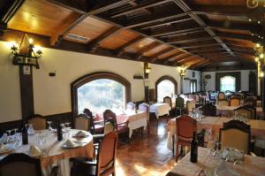 a restaurant with tables and chairs in a room at Hotel Milagros Rio Riaza in Milagros