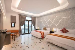 Habitación de hotel con 2 camas, escritorio y ventana en Kenting Fu-Jing Villa, en Hengchun