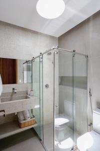 a bathroom with a glass shower and a sink at Casa Maçunim 1 in Pôrto de Pedras