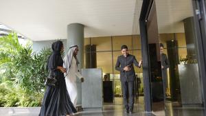 a bride and groom standing in front of a building at Fezinn Hotel - Best Wayanad Hotel in 2024 in Kozhikode
