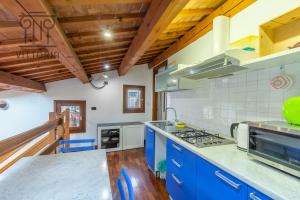 een grote keuken met blauwe kasten en een fornuis bij Vittoria Apartments Corso Andrea Palladio in Vicenza
