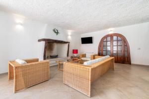 Elle comprend un salon doté d'un mobilier en osier et d'une cheminée. dans l'établissement Villa Eleonora Residence App to 4, à Capoterra