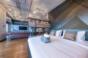 a large bedroom with a large white bed with a couch at Central Bangkok Loft Style Skyline 100 sq.m. Apt in Bangkok
