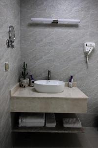 a bathroom with a sink with towels on a counter at Farah Hotel Apartment in Muscat