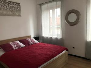 1 dormitorio con cama roja y ventana en Apartments Colors of Rijeka - Red en Rijeka