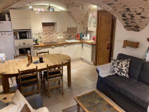 a kitchen and living room with a table and a couch at Two Bedroom Apartment La Voute, Chandon near Meribel - Sleeps 4 Adults or 2 Adults and 3 Children in Les Allues