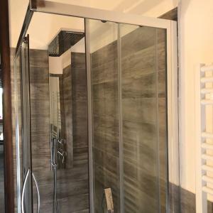 a shower with a glass door in a bathroom at Attico a 2 passi dalla stazione e centro storico in Ravenna