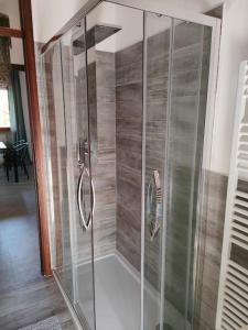 a shower with a glass door in a room at Attico a 2 passi dalla stazione e centro storico in Ravenna