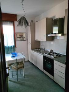 a kitchen with a table and a stove top oven at Attico a 2 passi dalla stazione e centro storico in Ravenna