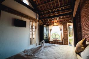 1 dormitorio con 1 cama en una habitación con ventana en Lim Village - Nam Ban en Namban