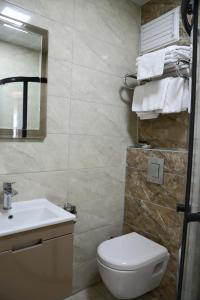 a bathroom with a toilet and a sink and towels at Otel 57 in Sinop