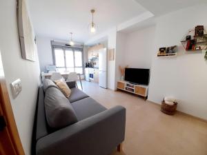 a living room with a couch and a television at Gestiona2R - Apartamento Lita in Posada de Llanes