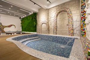 a swimming pool in a room with a tile wall at Kenting Fu-Jing Villa in Hengchun