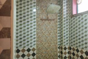 y baño con ducha y cortina de damasco. en IDMAT INN, en Davao City