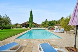 a swimming pool with lounge chairs and a house at Villa de 4 chambres avec piscine privee jardin amenage et wifi a Saint Sylvestre sur Lot in Saint-Sylvestre-sur-Lot