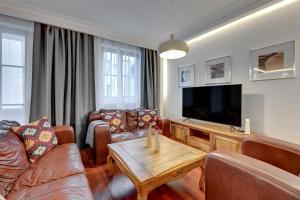 uma sala de estar com um sofá e uma televisão em Lion Apartments - Portofino Familly Apartment at the city center with parking em Sopot