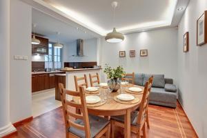 uma sala de jantar e cozinha com mesa e cadeiras em Lion Apartments - Portofino Familly Apartment at the city center with parking em Sopot