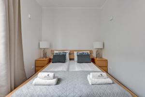 um quarto com uma cama com duas toalhas em Lion Apartments - Portofino Familly Apartment at the city center with parking em Sopot
