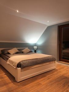 1 dormitorio con 1 cama con pared azul en Przystań nad Legą, en Olecko