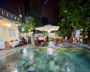 a pool in the middle of a restaurant at night at Garden House Nha Trang in Nha Trang