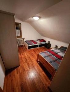 1 Schlafzimmer mit 2 Betten und Holzboden in der Unterkunft Ferienwohnung Michelle in Waldrach