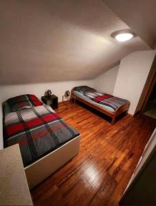 a bedroom with two beds and a wooden floor at Ferienwohnung-Michelle in Waldrach