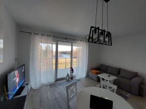 Televízia a/alebo spoločenská miestnosť v ubytovaní Apart Białe Augustów