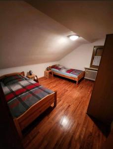 a attic bedroom with two beds and wooden floors at Ferienwohnung-Michelle in Waldrach
