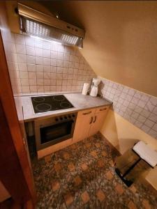 a kitchen with a stove and a tiled floor at Ferienwohnung-Michelle in Waldrach