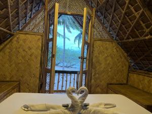 two swans laying on a table in a room with a window at Kanipa Beach Glamping in El Nido