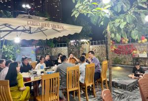 un grupo de personas sentadas en una mesa en un restaurante en Garden House Nha Trang, en Nha Trang