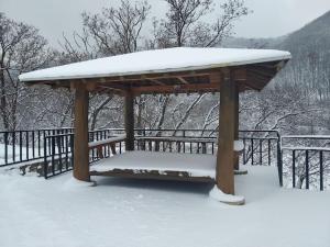 a wooden gazebo with snow on top of it at Lakeside Mirinae Villa in Anseong
