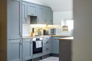 a kitchen with white cabinets and a stove top oven at Number 4 on The Hill in Lincolnshire