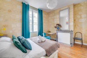 a bedroom with a bed with blue curtains and a fireplace at Chez Jeanne - Appartement Hyper Centre in Bordeaux