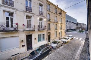 a row of cars parked in front of a building at Chez Jeanne - Appartement Hyper Centre in Bordeaux