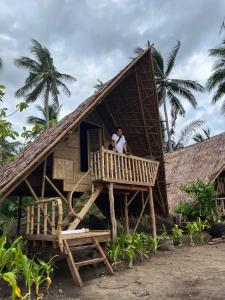 a man standing on a porch of a house at Kanipa Beach Glamping in El Nido