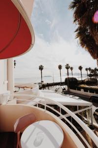 a balcony with a view of the beach and palm trees at Le Rose Thé in La Ciotat