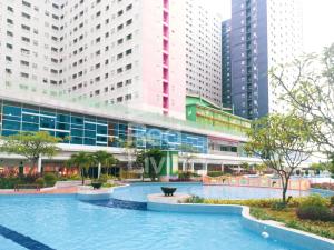 une grande piscine dans une ville avec de grands bâtiments dans l'établissement RedLiving Apartemen Green Pramuka - Family Group Tower Orchid, à Jakarta