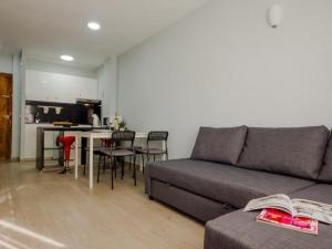 a living room with a couch and a table with chairs at Aparta-club la Barrosa 116 in Chiclana de la Frontera