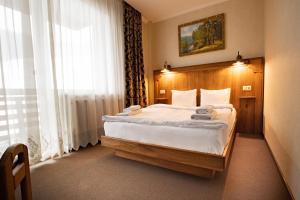 een slaapkamer met een bed en een groot raam bij Private Rooms in Hotel Lift 1R in Boekovel