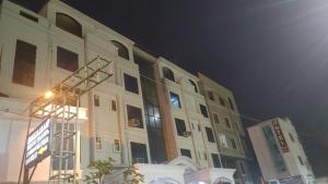 a large building with a light on the side of it at Hotel K J International in Pura Raghunāth